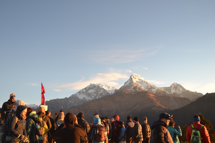 People gathered with mountains in the background.