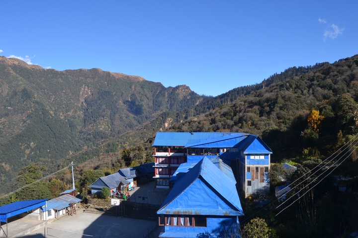 Village with blue-roofed houses in a mountainous area.