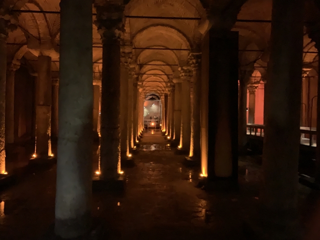 Dimly lit underground chamber with columns and arches.