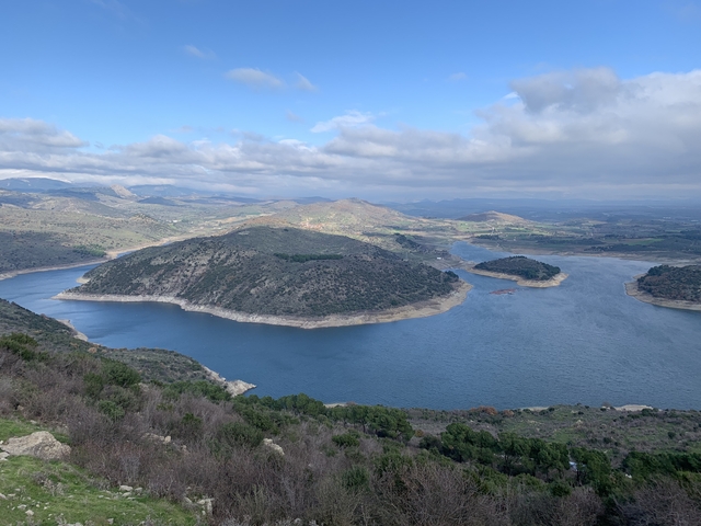 Scenic view of a large lake surrounded by hills.