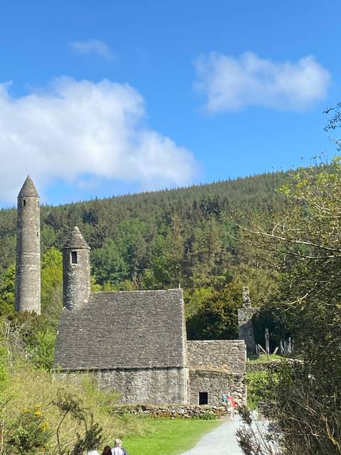      Old stone church in a lush setting.
  
