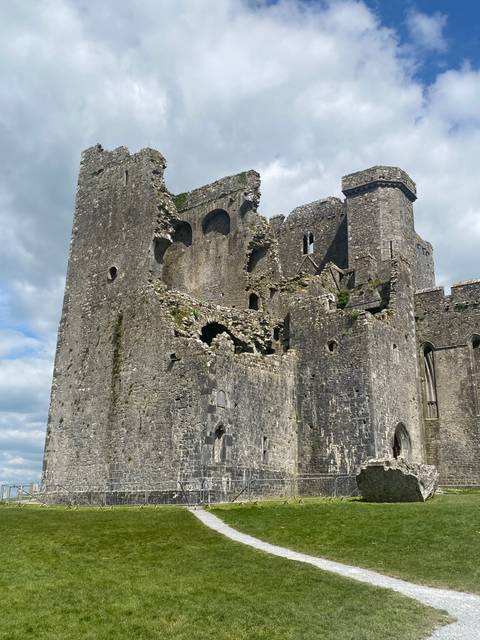       Ruins of a stone castle under a blue sky.
  