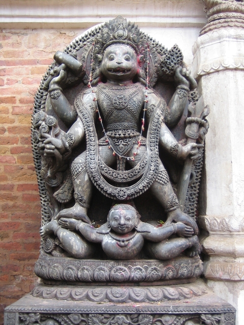 Stone carving of a deity with intricate details.