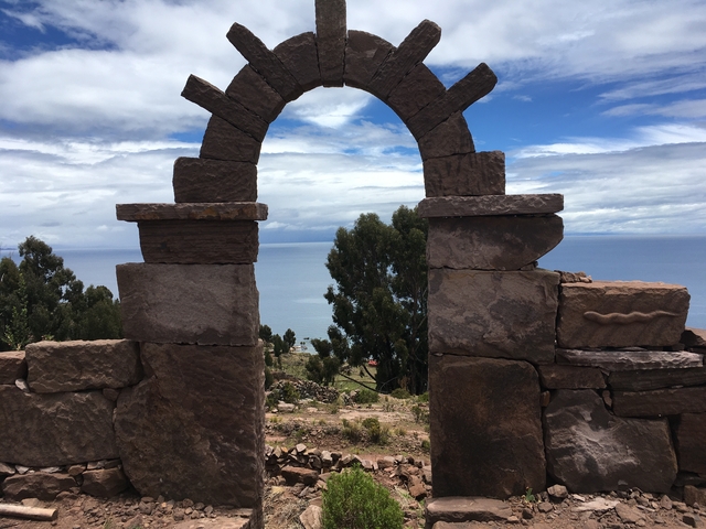       Stone arch with a lake view in the background.
  