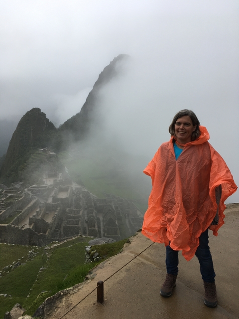       Person in a rain poncho at Machu Picchu with foggy background.
  
