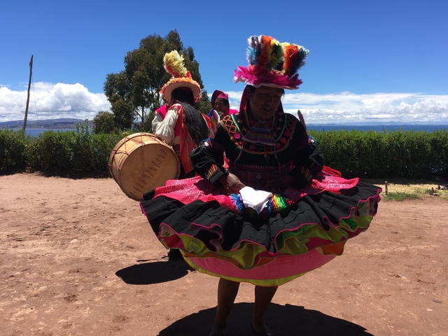       Colorfully dressed performers with drums outside.
  