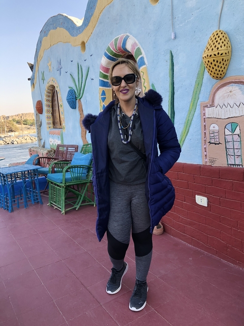 Person standing in front of colorful building.