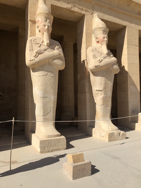 Two large statues standing before a building.
