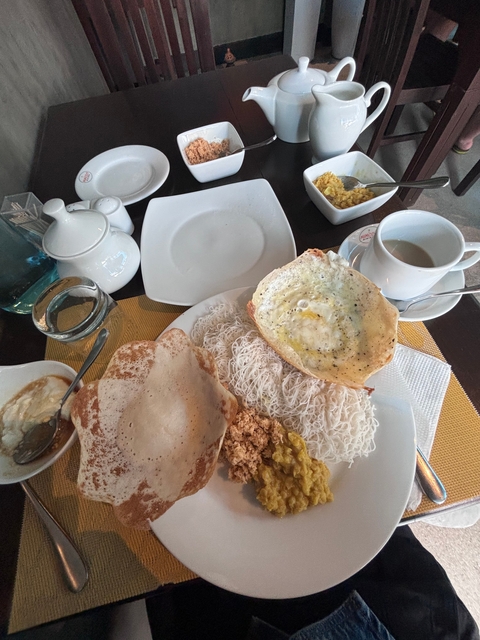       Traditional Sri Lankan breakfast spread with tea and dishes.
  