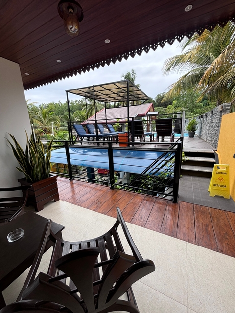       Poolside view with seating area and lounge chairs.
  