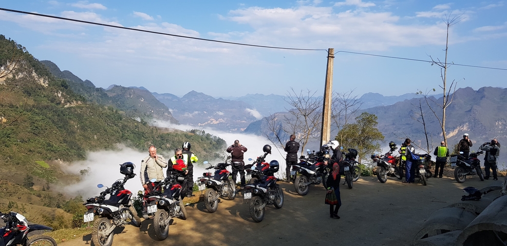 Group of motorcyclists with a mountain landscape in the background.