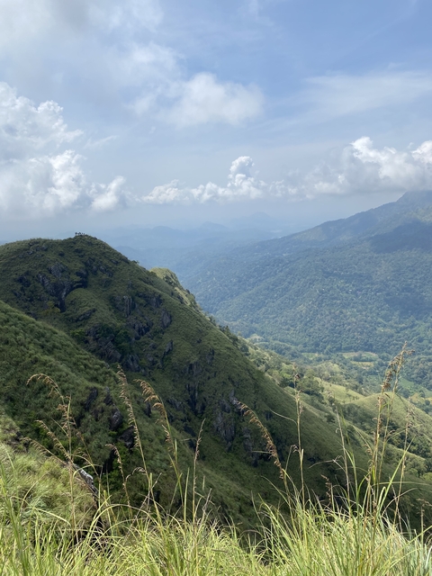 Scenic view of lush mountain terrain beneath a blue sky.