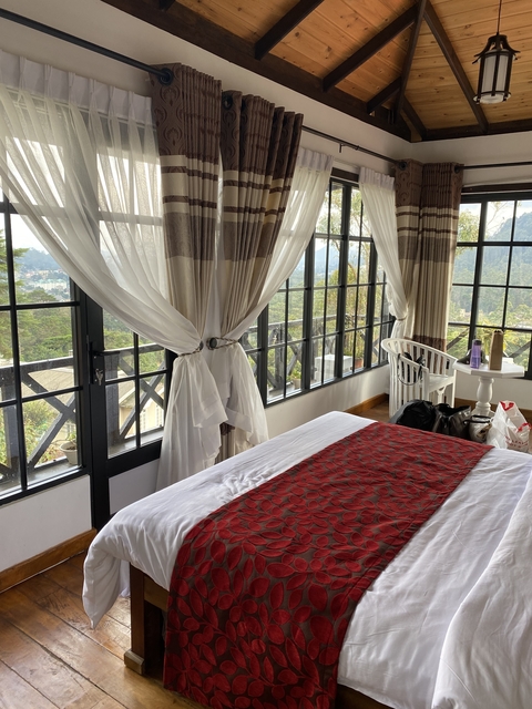       Hotel room with a view of mountains and greenery.
  