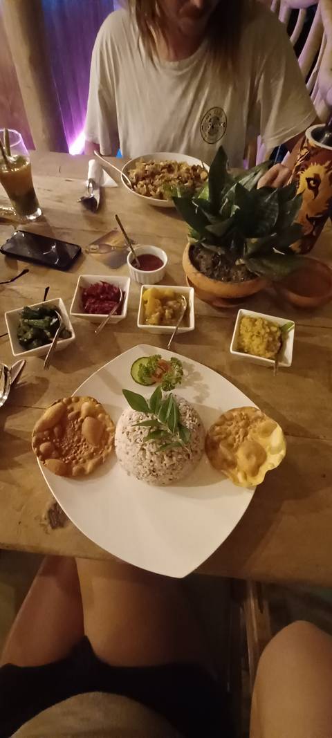 Table with various dishes and people dining.