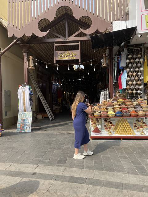 Busy market street with shopper and stalls.