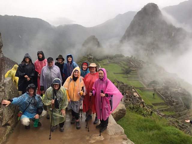       Group in colorful rain ponchos at Machu Picchu ruins.
  