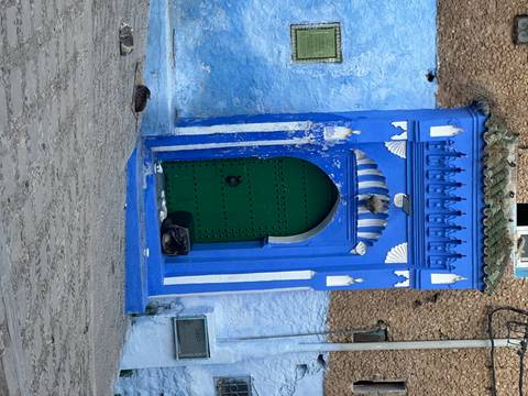       Blue arched door with intricate detailing in Chefchaouen.
  