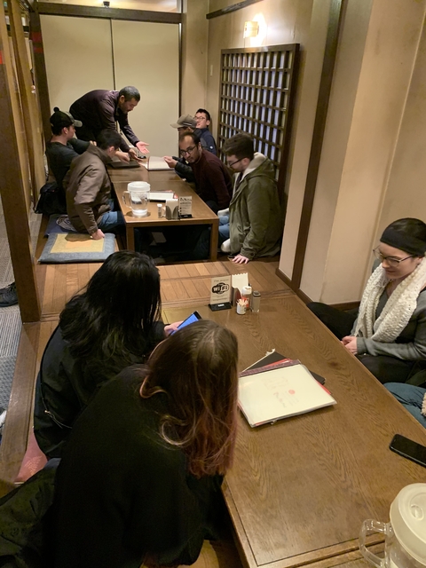 People sitting in a traditional Japanese dining setup.