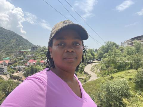 Person with a cap outdoors under blue skies.