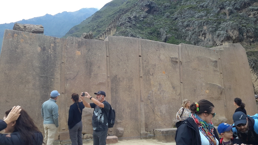       Tourists near large stone structures in an archaeological site.
  