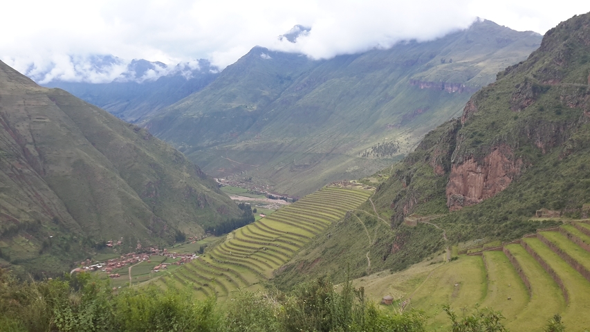       Terraced landscape with mountains under a cloudy sky.
  