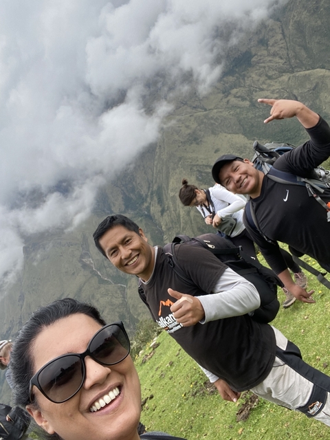       Group of hikers posing with mountains in the background.
  