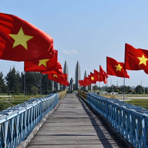       Flags on a bridge leading to a memorial structure.
  