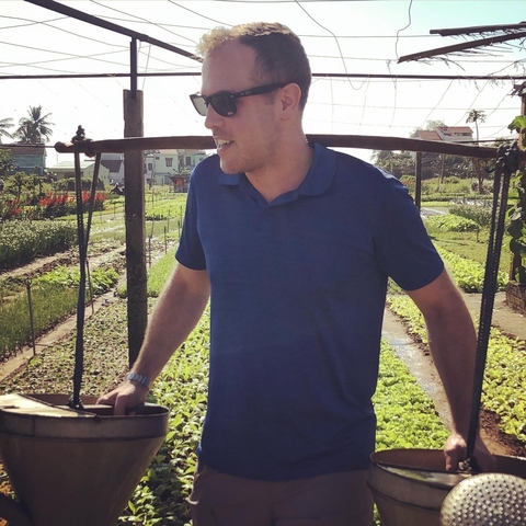       Person in blue shirt working in a farm field.
  