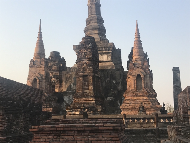 Ancient temple with spires and brickwork under clear skies.