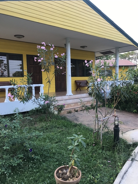 Yellow and white house with garden and flowers.