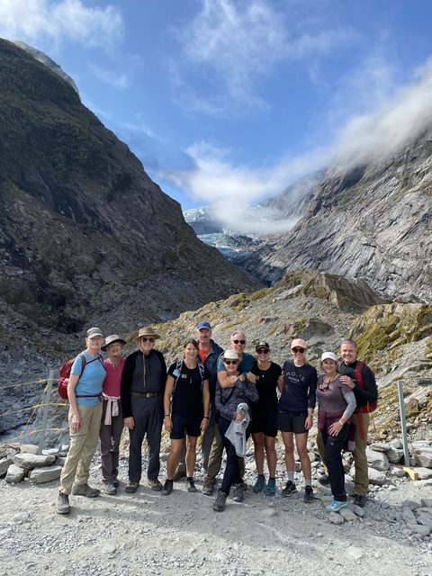       Group of hikers in front of a glacier.
  