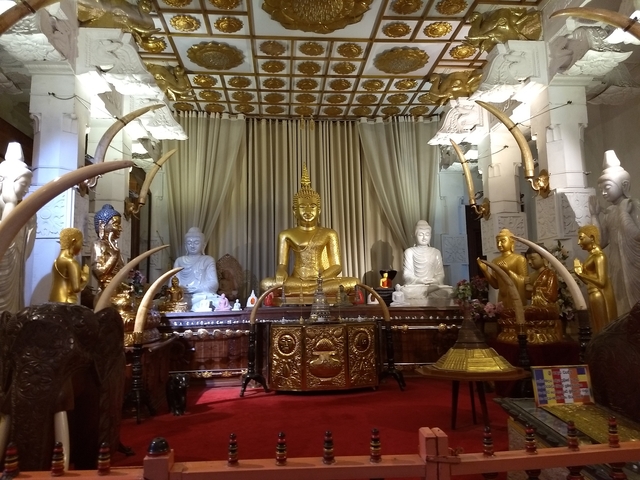 Interior of a temple with golden Buddha statues.