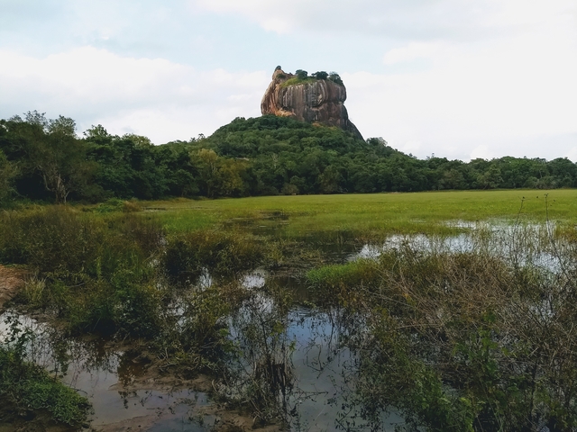 Dramatic rock formation rising from a landscape.