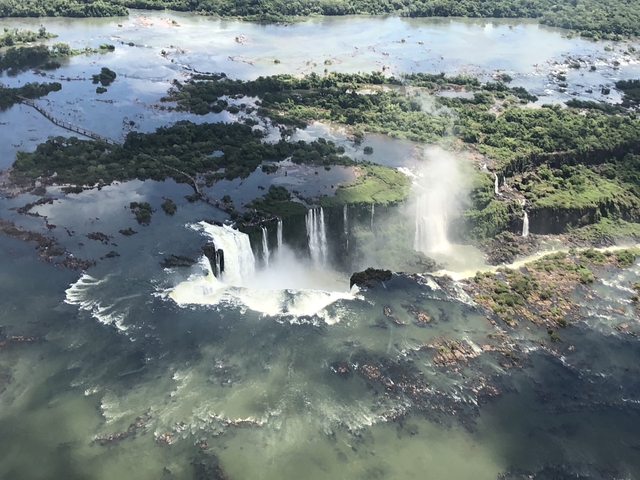 Aerial view of Iguazu Falls surrounded by lush greenery.