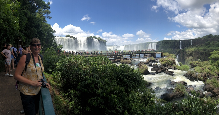 Tourist posing with a panoramic view of Iguazu Falls.
