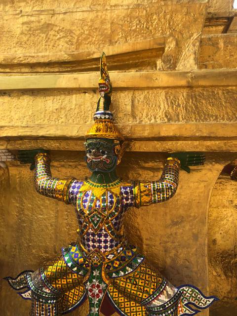       Colorful figure embedded in a golden wall.
  