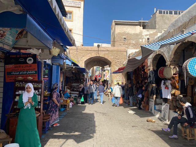       Busy street market with various goods and people.
  