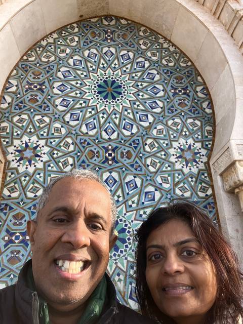       Close-up of two people with ornate tiles.
  