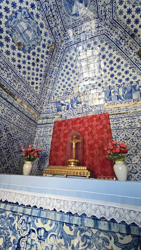 Ornately decorated blue and white tiled room with a religious relic.