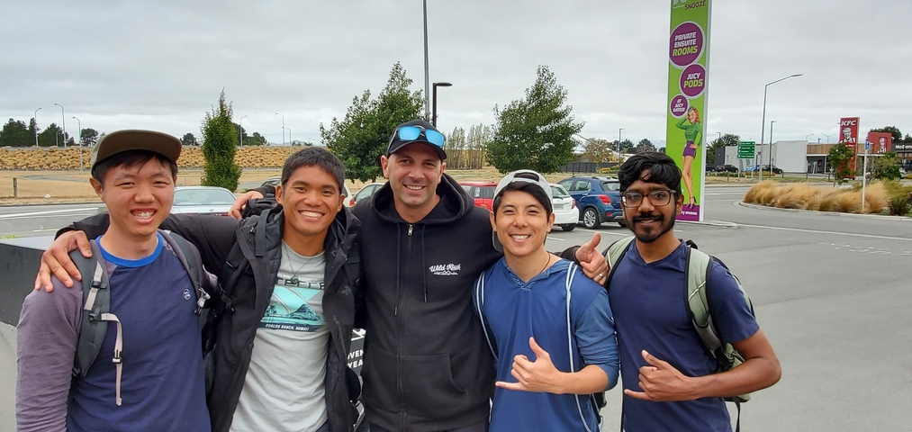       Group of friends posing in a parking lot.
  