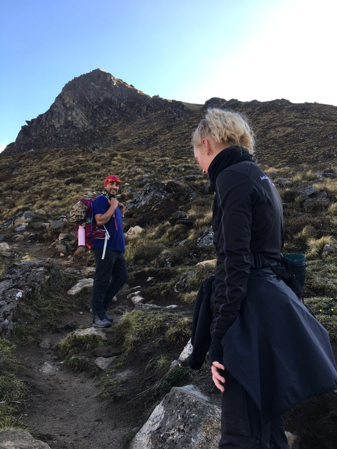 Two people hiking in a mountainous landscape.