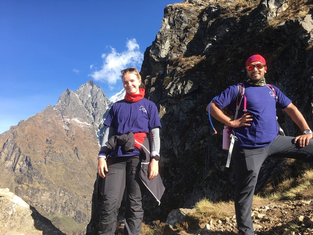 Two people posing in front of a high peak.
