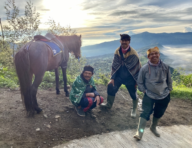       Three men with a horse on a mountain, overlooking the scenery.
  