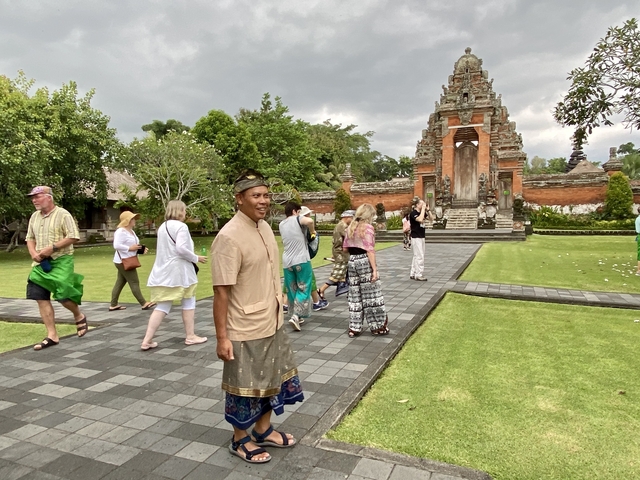      Tourists exploring a historic building with a traditional gate.
  