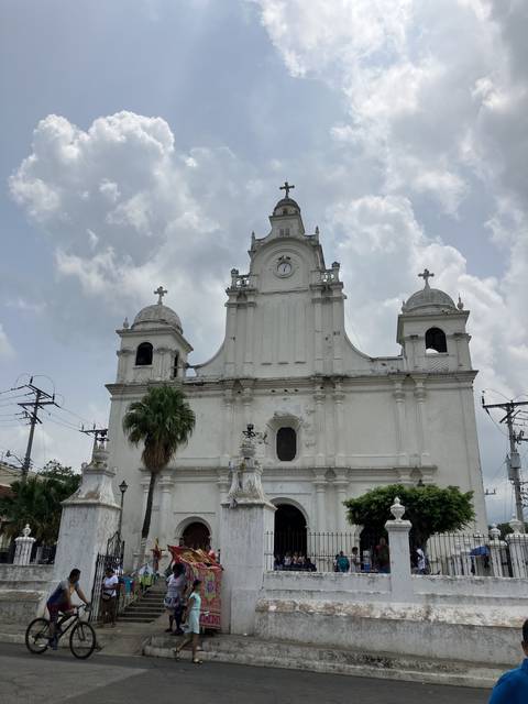 White church building with people in the front.