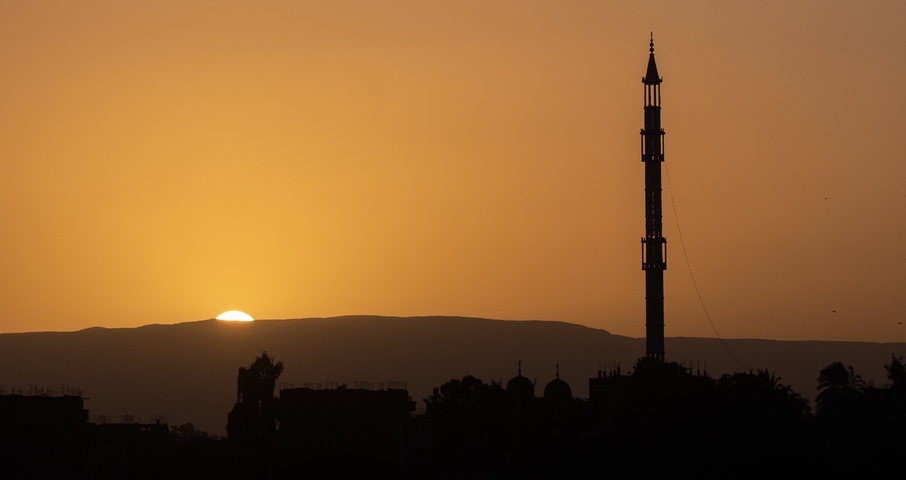       Silhouette of a minaret during sunset.
  