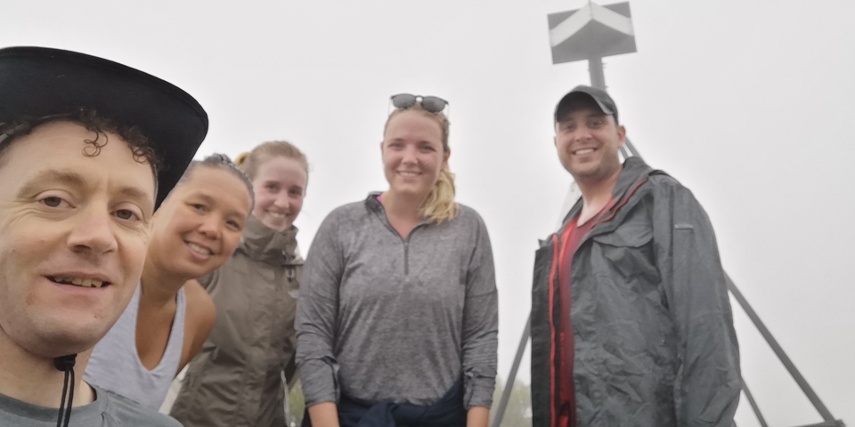      Group of people on a foggy mountaintop.
  