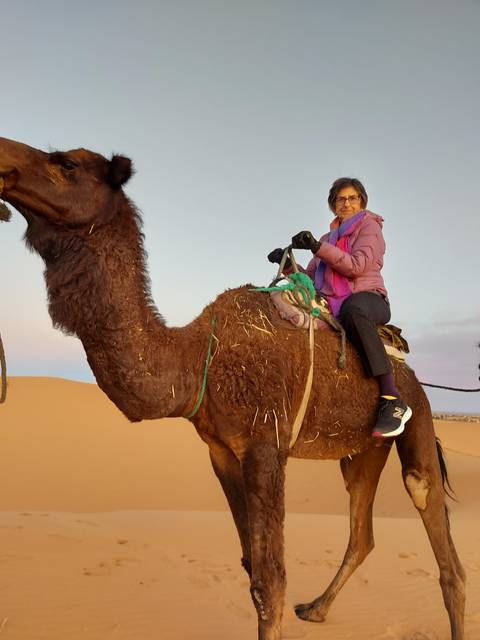A person riding a camel in the desert.