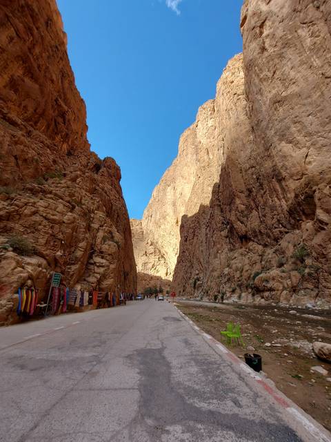 A narrow gorge with a road and colorful chairs.