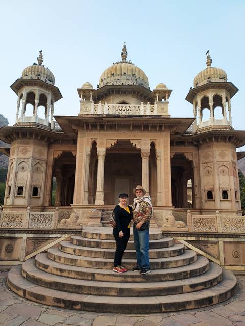       Two people posing in front of an ornate building.
  